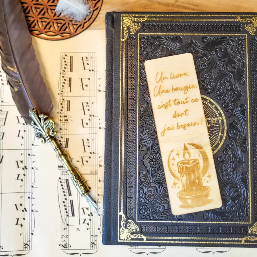 Marque-page en bois gravé avec citation manuscrite « Un livre, une bougie », lune, étoiles et bougie allumée