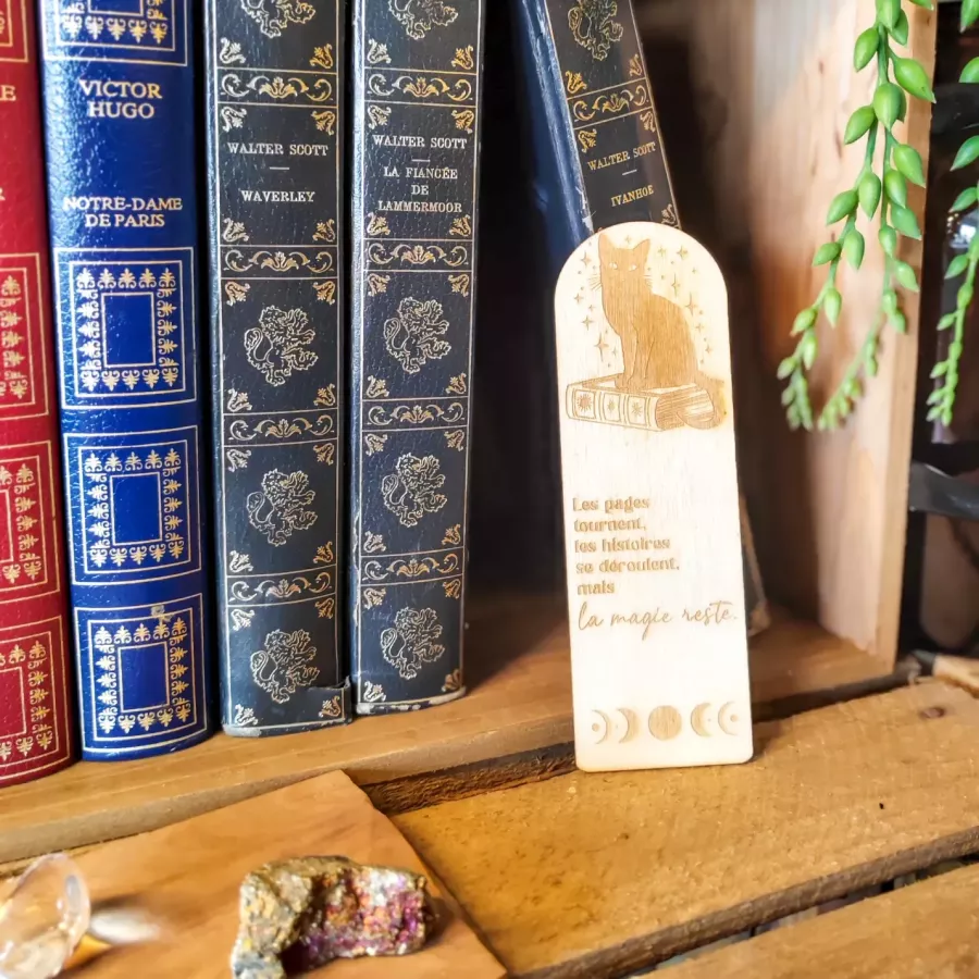 Marque-page en bois avec un chat assis sur un livre, phases de la lune et citation